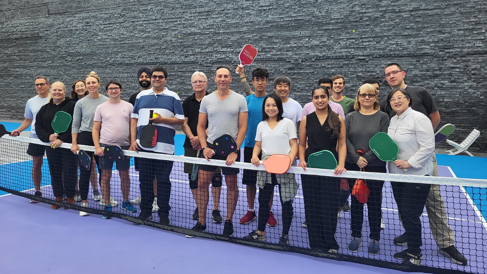 Group of Stern Cohen Accountants posing for a team photo on the pickleball court